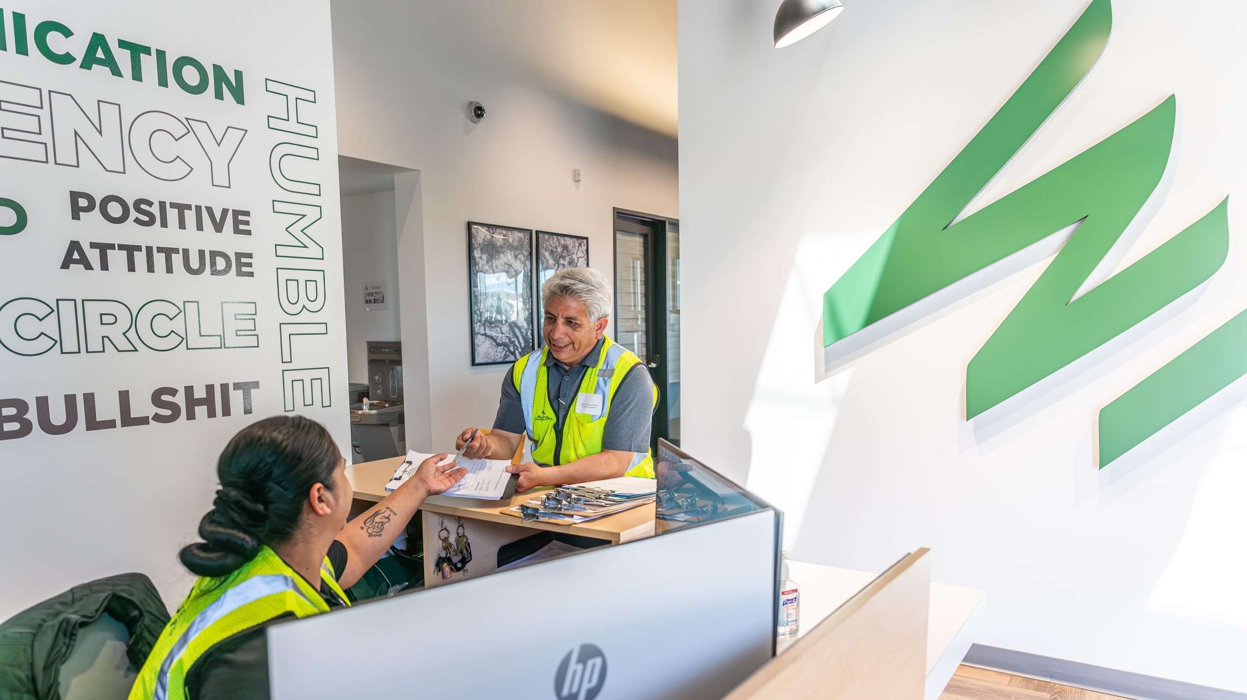 Alpine Tree Care team members reviewing permit documents for tree service compliance at the front desk